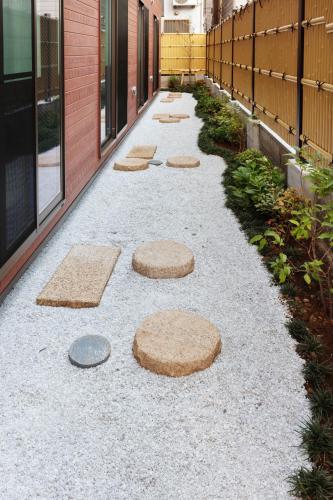 a walkway with stepping stones on the side of a building at Guest House Wagokoro in Tokyo