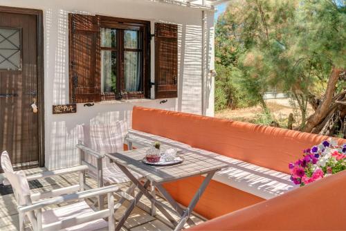 a patio with a table and chairs on a porch at Anemologio in Finikas