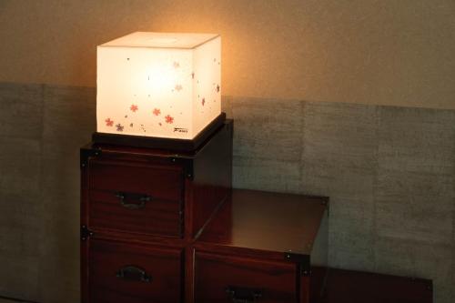 a box on top of a dresser with a lamp on it at Guest House Wagokoro in Tokyo