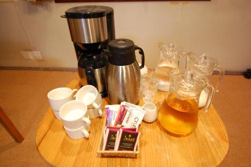 a coffee maker on a wooden table with drinks at Guest House Chaconne Karuizawa in Karuizawa
