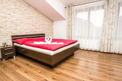 ein Schlafzimmer mit einem Bett mit einer roten Decke in der Unterkunft Apartment Downtown in Žilina