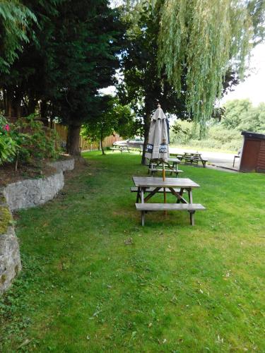 a picnic table with an umbrella in a park at The Railway Inn in Forden