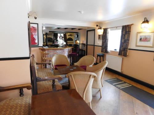 a restaurant with tables and chairs and a bar at The Railway Inn in Forden