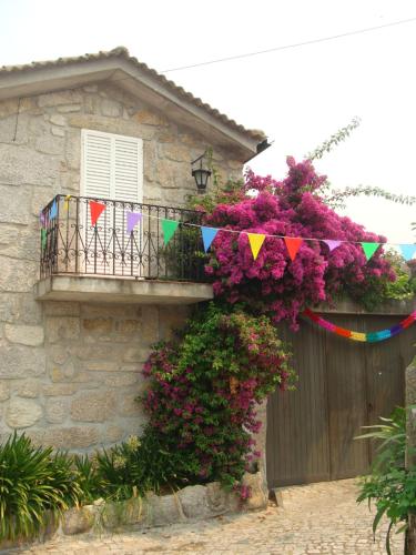 a building with a balcony with flowers and bunting at Casa das Magnólias de Igarei in Igarei