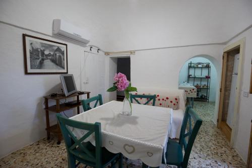 a dining room with a table with a vase of flowers on it at B&B Tenuta Ranieri in Selva di Fasano