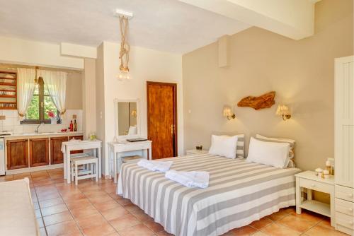 a bedroom with a large bed and a kitchen at Anemologio in Finikas