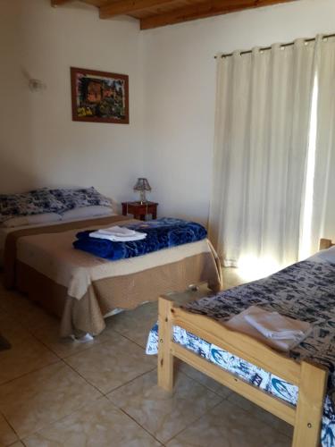 a room with two beds and a window at Apartamentos Centricos Puerto Iguazu in Puerto Iguazú