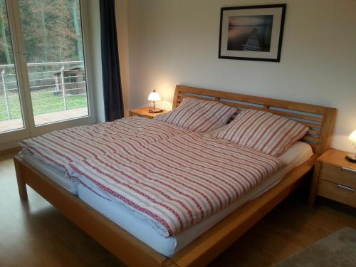uma cama com um edredão listrado num quarto em Ferienwohnung an der Hasenburg em Lüneburg