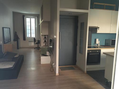 Il dispose d'une cuisine et d'un salon avec un canapé. dans l'établissement Le Mourillon Appartement -Terrasse, à Toulon