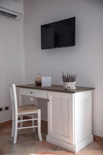 a desk with a television on a wall with a chair at Anima Antiqua Relais & Spa in Gioia Sannitica
