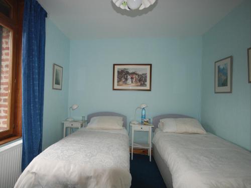 2 camas en una habitación con paredes azules en The Silent Picket, en Martinpuich