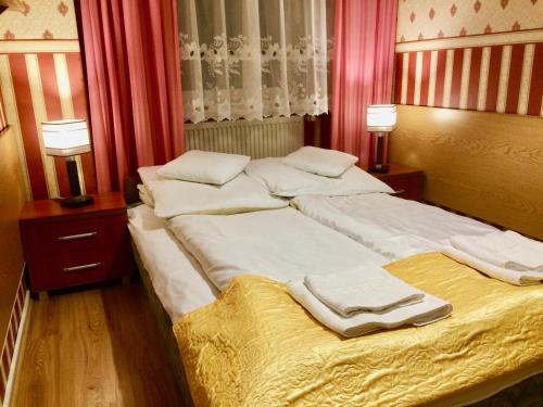 a bedroom with two beds with towels on them at Hotel i Restauracja Sara in Polanica-Zdrój