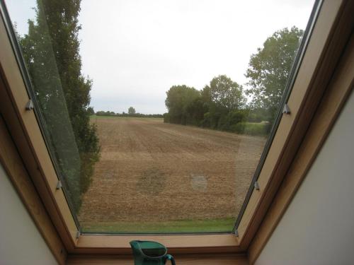 a window with a view of a field at Naboløs Rooms, near Munkebo, Kerteminde and Nyborg in Bovense