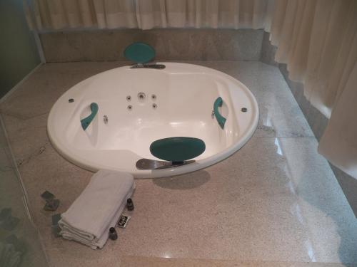 a bath tub sitting in the middle of a bathroom at Passer Hotel in Lençóis Paulista