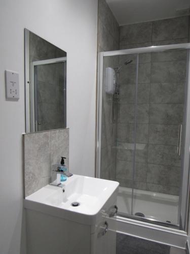 a bathroom with a white sink and a shower at Pear Tree Inn in Welwyn Garden City
