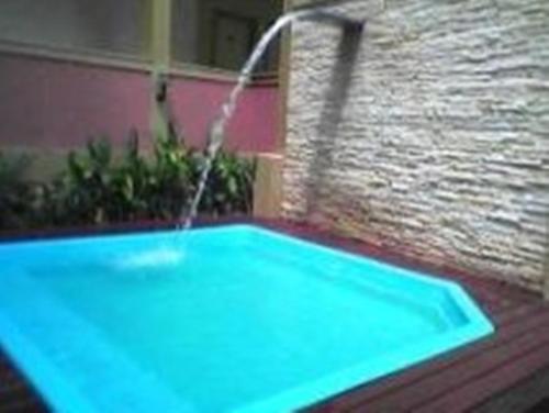 a faucet spraying water over a swimming pool at Café Palace Hotel in Três Pontas