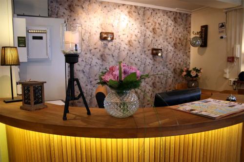 a round table with a vase of flowers on it at CarlstadCity H Boutique Hotell in Karlstad