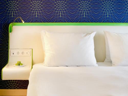 a bed with white pillows and a blue wall at Park Inn by Radisson Amsterdam City West in Amsterdam