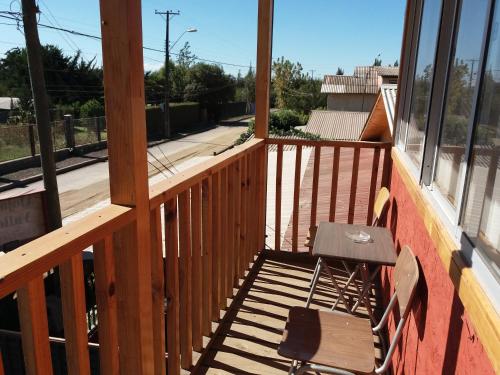 a wooden balcony with a bench and a window at Alojamiento Valle Verde in Isla de Maipo
