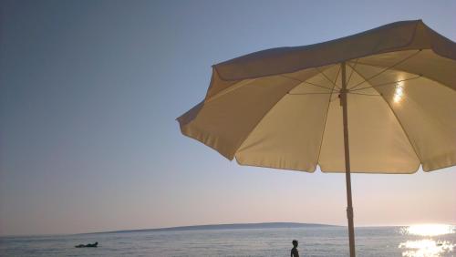 a person standing on a beach with an umbrella at Apartment Feliks in Mandre