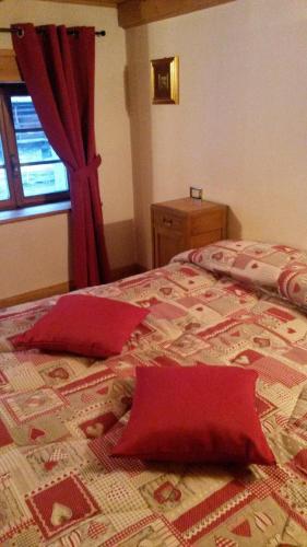 a bedroom with a bed with red pillows on it at Chalet Martina in Macugnaga