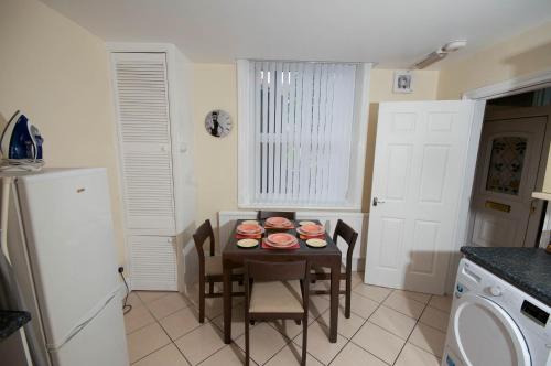 a kitchen with a table with plates on it at Marley Mansion Apartments - Borough in Birkenhead