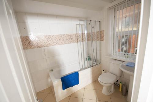 La salle de bains est pourvue de toilettes et d'une serviette bleue. dans l'établissement Marley Mansion Apartments - Borough, à Birkenhead
