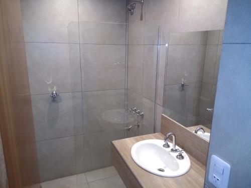 y baño con lavabo y ducha. en Hotel Tunuyan en Tunuyán