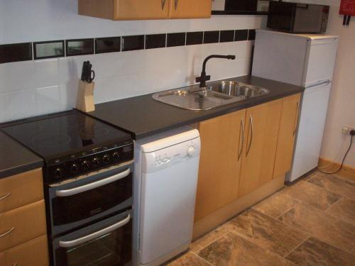 a small kitchen with a sink and a stove at Homestead Stables in Market Lavington