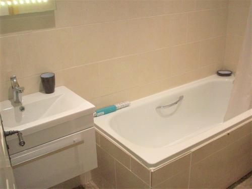 a bathroom with a sink and a bath tub with a toothbrush at Homestead Stables in Market Lavington
