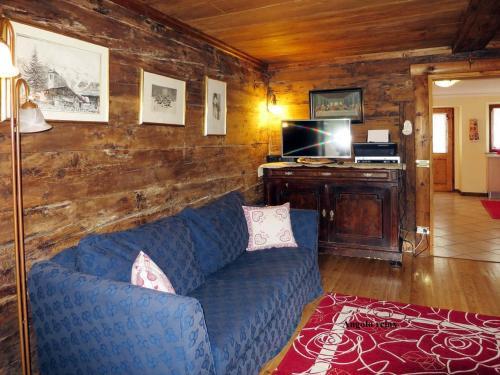 a living room with a blue couch and a tv at Chalet Martina in Macugnaga