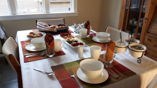 un tavolo con una tovaglia bianca con del cibo sopra di Campbell Cottage B&B a Nanaimo