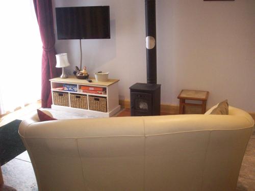 a living room with a white couch and a stove at Homestead Stables in Market Lavington