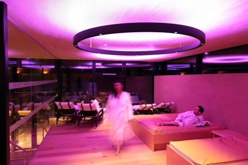 a person walking in a room with beds and people sitting at Hotel Adler in Warth am Arlberg