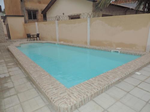 a large swimming pool with blue water at Regal Apartments in Kololi