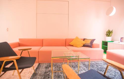 a living room with an orange couch and chairs at Isabella Living in Maribor