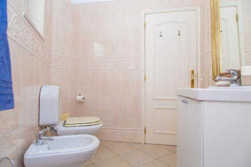 uma casa de banho branca com um WC e um lavatório em Porque Você Merece em Quarteira