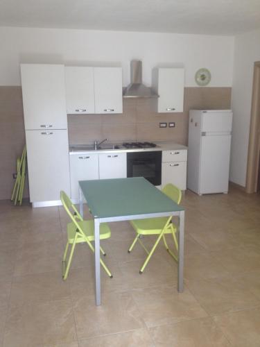 a kitchen with a table and two chairs at fausthome in Assemini