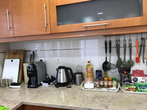 a kitchen counter with utensils hanging on a wall at Bing Garden Guesthouse in Lisbon