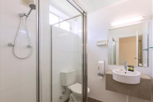 a bathroom with a shower and a toilet and a sink at BreakFree Queanbeyan in Queanbeyan