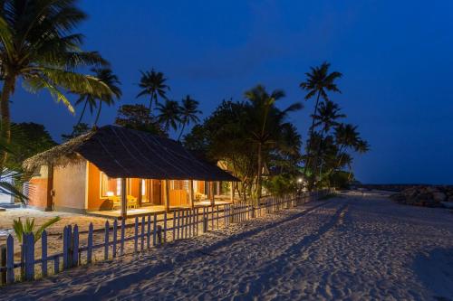 a resort on the beach at night at Azure Tides Marari in Mararikulam