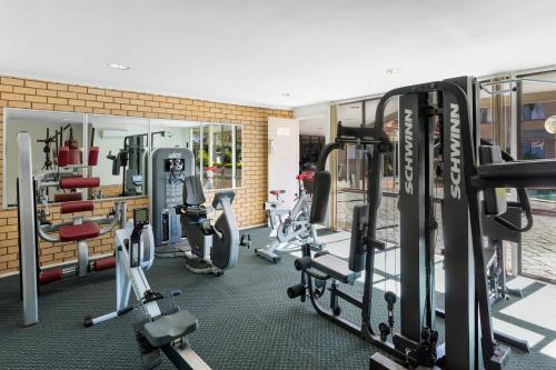 a gym with several treadmills and exercise bikes at Garden City Hotel, Best Western Signature Collection in Canberra