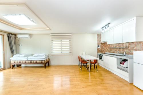 a kitchen with white cabinets and a table with chairs at Jeju I've Hotel & Resort in Seogwipo