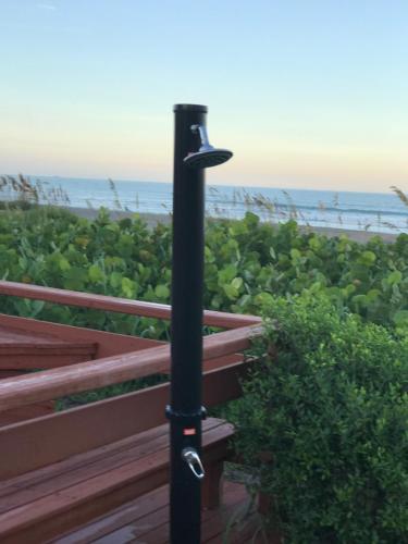 a black pole with a bird feeder next to a bench at South Beach Inn - Cocoa Beach in Cocoa Beach