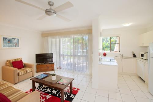 a living room with a couch and a table at Melaleuca Resort in Palm Cove