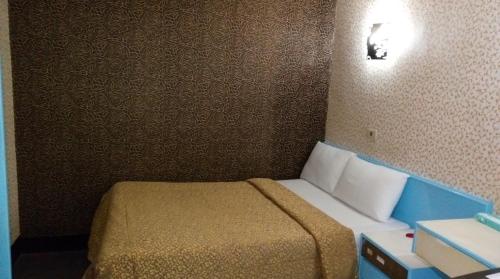 1 dormitorio pequeño con 1 cama en una habitación en Reui Chung Hotel en Kaohsiung