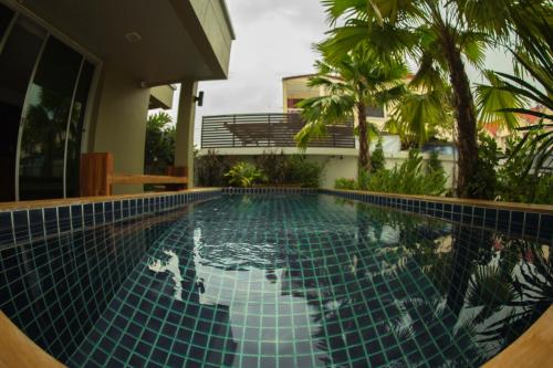 uma piscina no meio de uma casa em The Suvarnabhumi Apartment em Bang Kew Yai