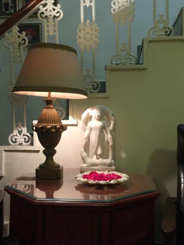 a lamp sitting on a table next to a statue at Barwara Kothi in Jaipur