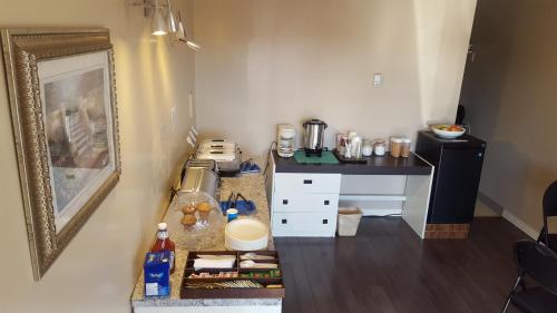 a small kitchen with a counter and a table at Siesta Motel in Olds