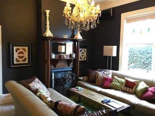 a living room with two couches and a chandelier at 94 Highett - 5 bedroom, 3 car parks - Luxury House in Melbourne